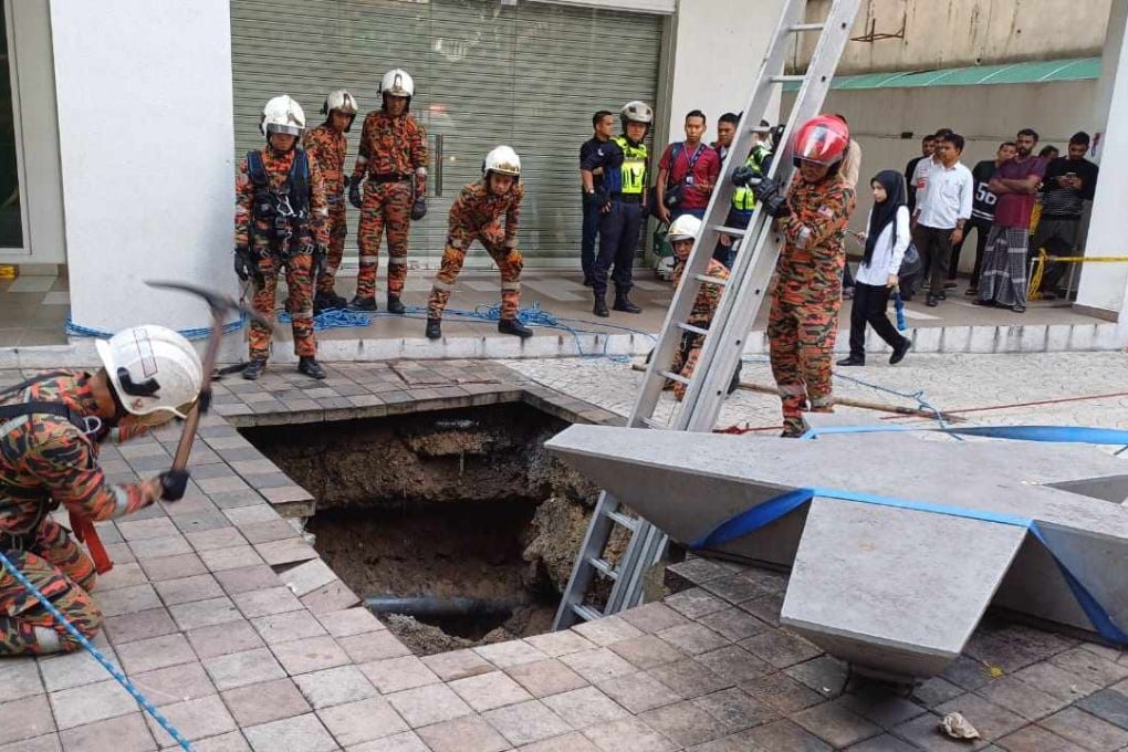 Crews work to rescue a woman who fell into a sinkhole on a busy Kuala Lumpur street. Photo: Kuala Lumpur Fire and Rescue Department