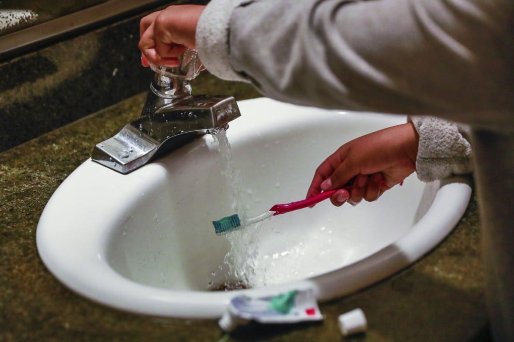 A child rinses a toothbrush in San Francisco in June 2019. Photo: San Francisco Chronicle via AP