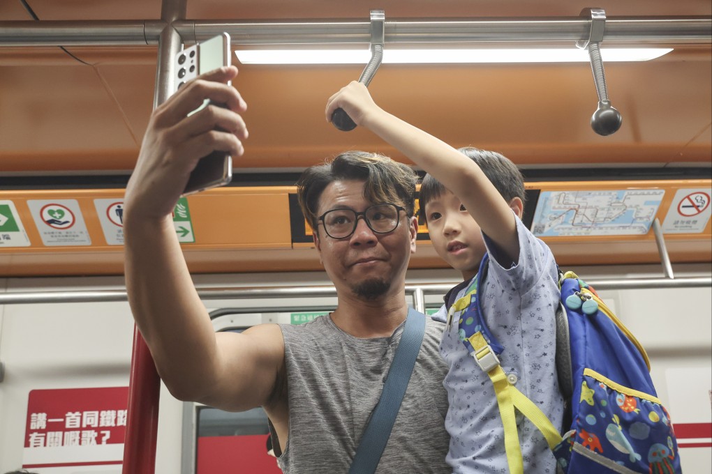 A father introduces his son to old-style hand straps in one of the carriages. Photo: Edmond So