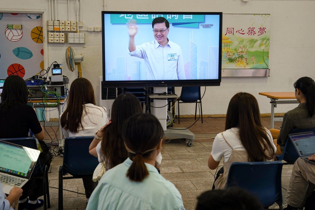 Chief Executive John Lee is seen on a TV screen as he leaves the first town hall meeting at a school in Tai Po on August 18. Photo: Elson Li