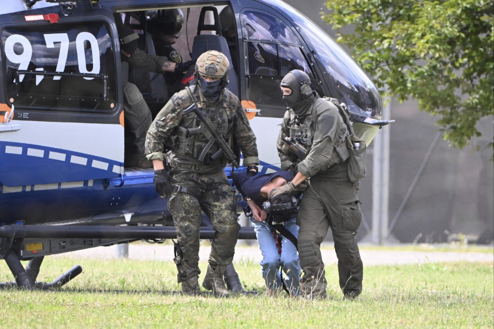 Police escort a suspect from a helicopter in Karlsruhe, Germany on Sunday after a stabbing attack in the city of Solingen left 3 dead and 8 wounded. Photo: dpa via AP