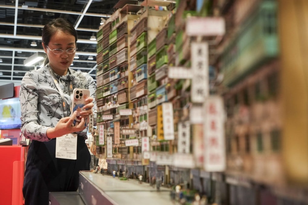 A woman takes a photo of a diorama of Kowloon Walled City is showcased at an exhibition at the Hong Kong Book Fair on July 14. An expanded gallery featuring the city’s urban development could be a tourist attraction. Photo: Elson Li
