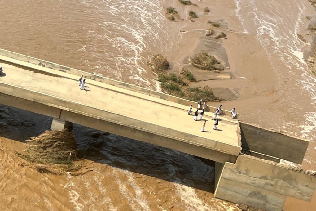 People on a bridge damaged due to floods after the collapse of Arbaat Dam. Photo: Sudan’s Transitional Sovereign Council via Xinhua