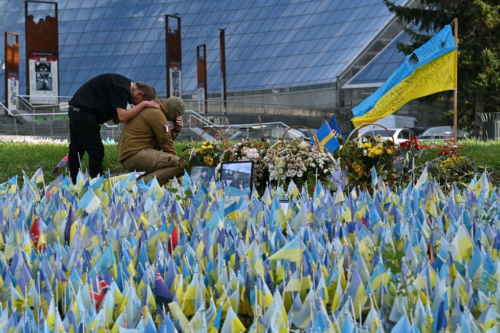 A serviceman and his friend pay tribute to their fallen comrades in the Independence Square in Kyiv, on October 30, 2023, amid the Russian invasion of Ukraine. Photo: TNS