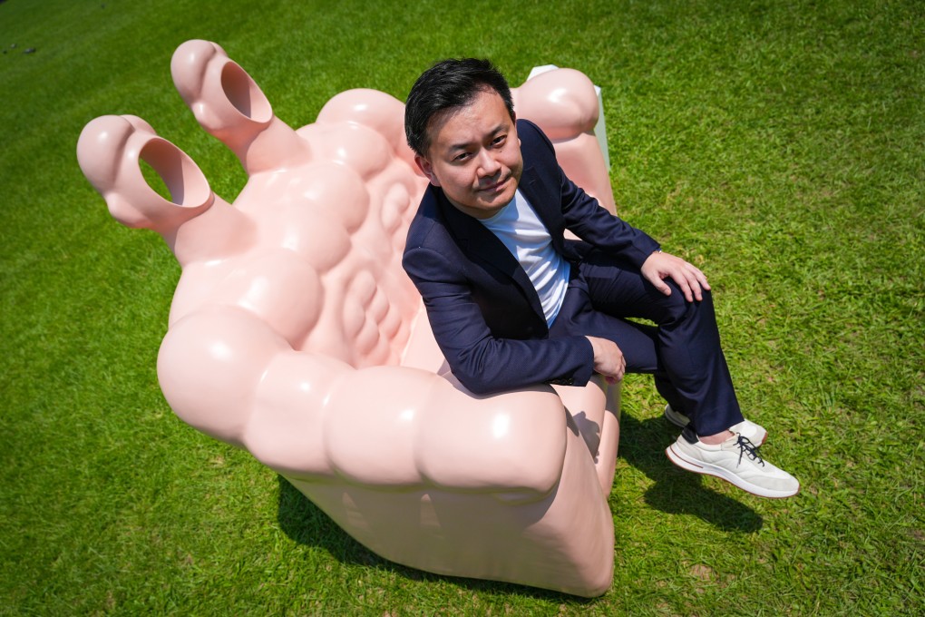 Art021 co-founder David Chau poses with an artwork named “Sofa man” by Shang Liang in Victoria Park. Photo:  Eugene Lee