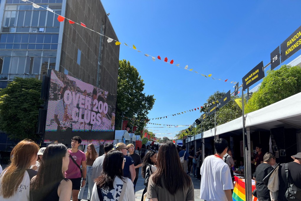 Students walk past stalls during orientation week at The University of Sydney. Photo: Reuters