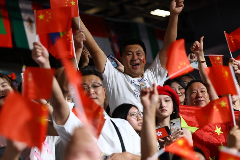 Fans wave China flags as the Hong Kong flag is displayed on a phone, before the table tennis mixed doubles semi-final between Hong Kong and North Korea at the Paris Olympics on July 29. Photo: Reuters