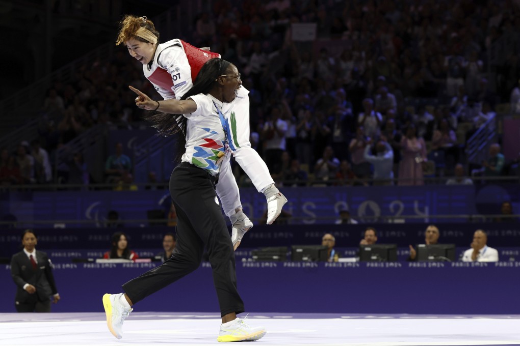 Zakia Khudadadi from the Paralympic Refugee Team is carried by her French coach Haby Niare after she won the bronze medal. Photo: AP