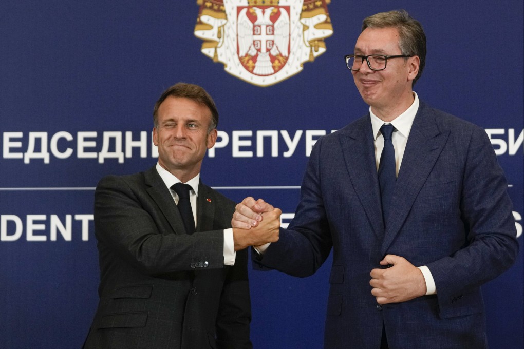 French President Emmanuel Macron clasps hands with Serbian President Aleksandar Vucic. Photo: AP