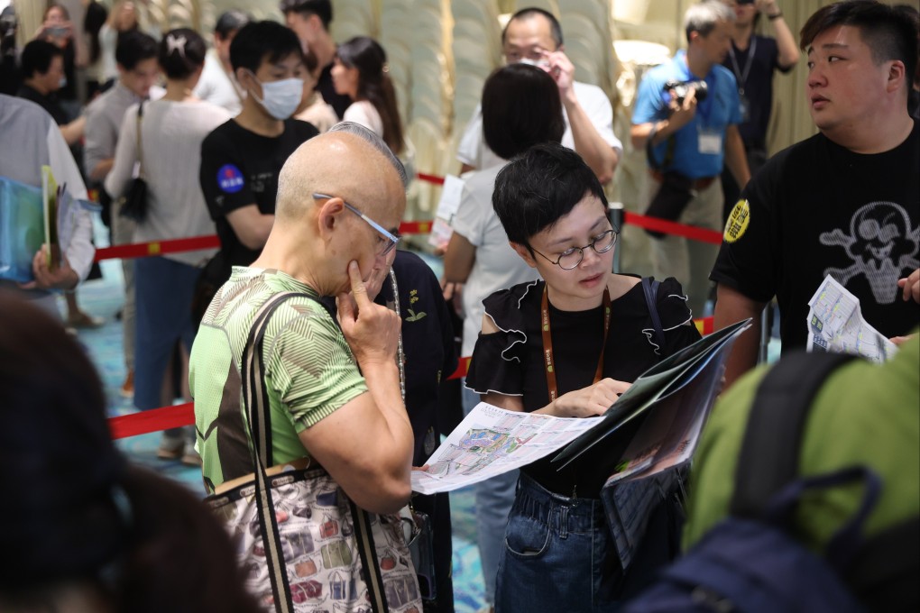 Potential buyers study the sales brochure of The Uppland, a development in Tuen Mun, at the sales office in Tsim Sha Tsui on July 20. Photo: Edmond So