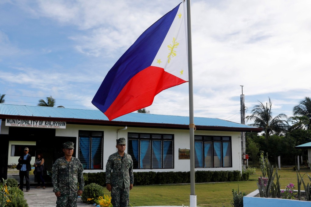 Filipino soldiers stand at attention near a Philippine flag on Thitu Island in the disputed South China Sea in April 2017. Photo: Reuters