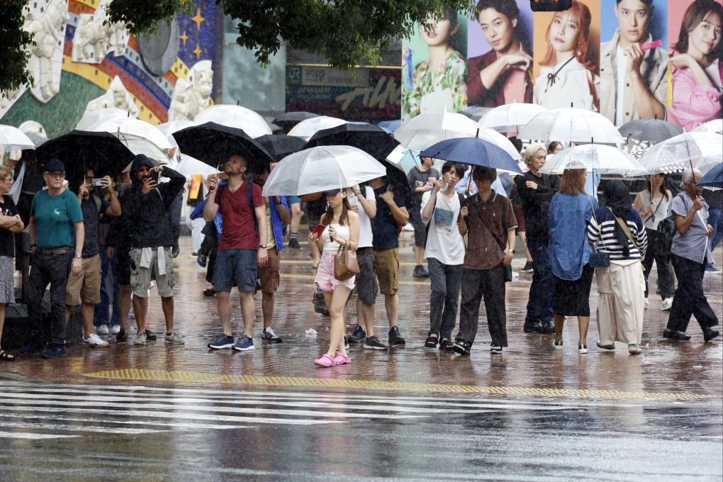 Pedestrians stand holding umbrellas under rainfall at Shibuya crossing in Tokyo, Japan, August 30, 2024. Tama river reached the level 4 out 5 on the flood hazard scale earlier in the day. Photo: EPA-EFE
