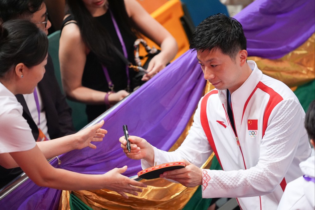 Chinese table tennis star Ma Long signs an autograph for fans during an event at Queen Elizabeth Stadium in Wan Chai. Photo: Eugene Lee