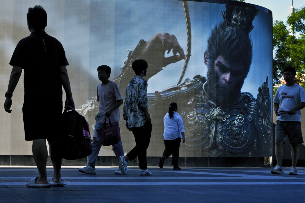 People walk past a large screen advertising China’s latest blockbuster video game, Black Myth: Wukong, outside a commercial office building in Beijing on August 27, 2024. Photo: AP