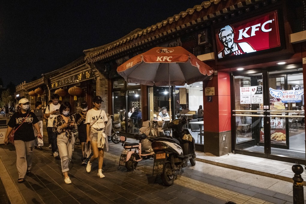 Pedestrians walk past a KFC stall and outlet in Beijing. Photo: Bloomberg