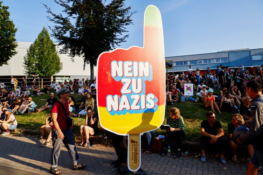 People sit near a sign that reads “No to Nazis” on the day of the Thuringia state election in Erfurt, Germany on Sunday. Photo: Reuters