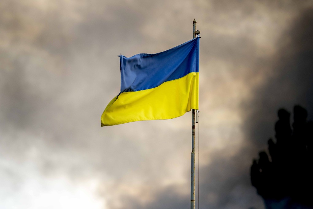 A Ukrainian flag seen in front of thick smoke rising from a fire over Kyiv after Russian missile attacks on Ukraine. Photo: Zuma Press Wire/dpa
