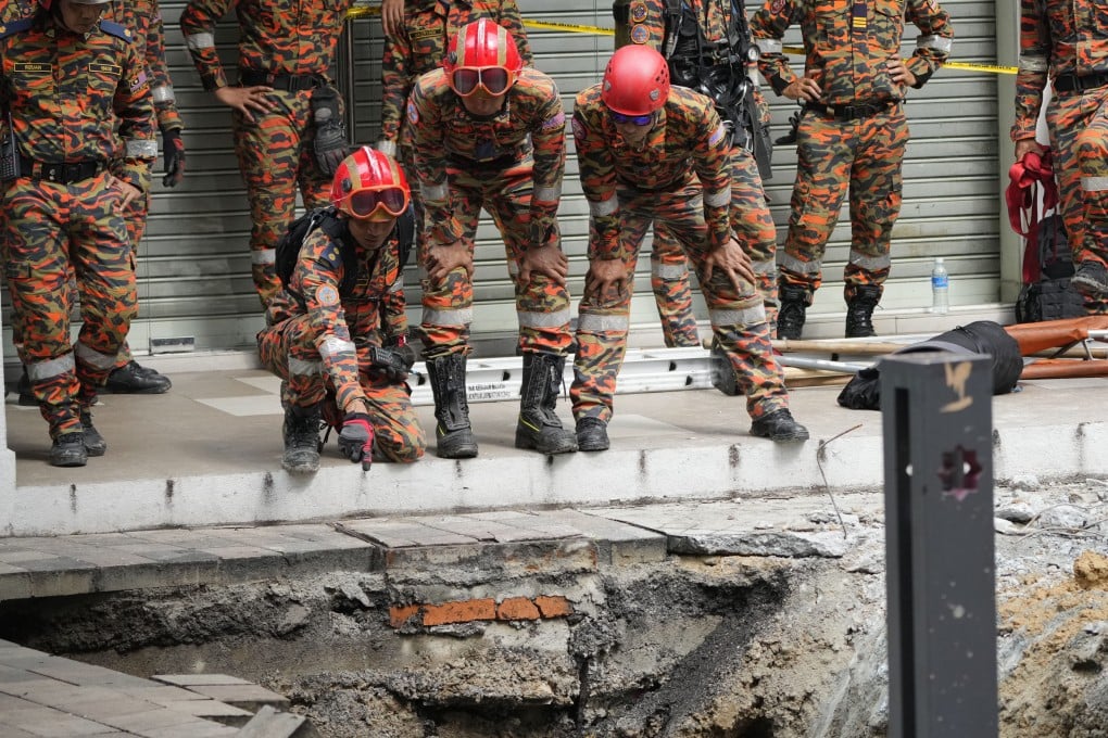 Rescuers check the sinkhole that opened up in Kuala Lumpur on August 23. Photo: AP