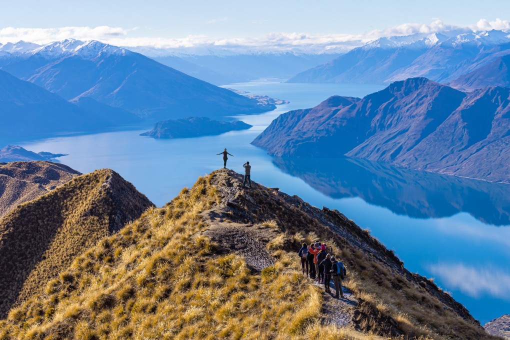 Tourists take photos atop Roy’s Peak at Lake Wanaka in New Zealand. Photo: Shutterstock