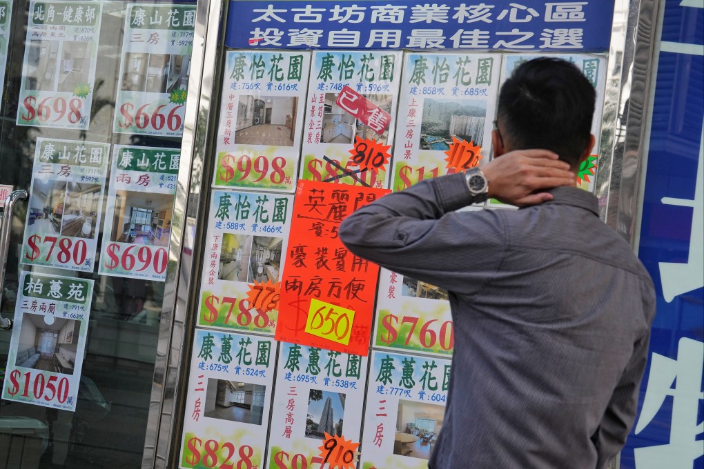 Real estate ads are displayed on the window of a property agency in Quarry Bay. Photo: Elson LI