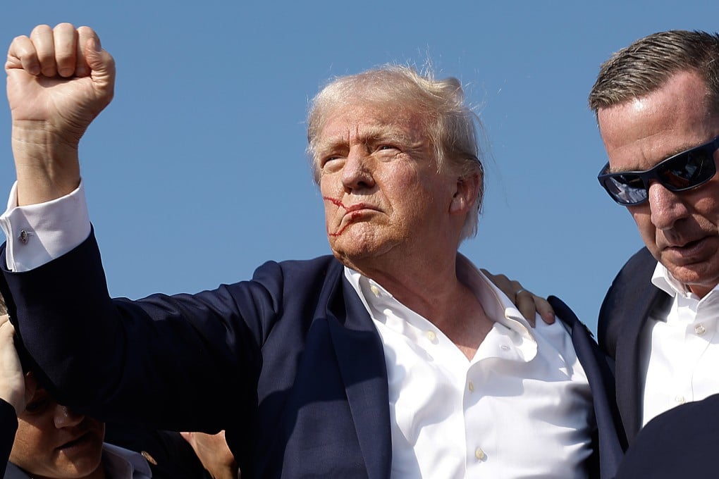 Donald Trump pumps his fist as he is rushed off stage by Secret Service agents after being grazed by a bullet during a campaign rally in July. Photo: Getty Images/TNS