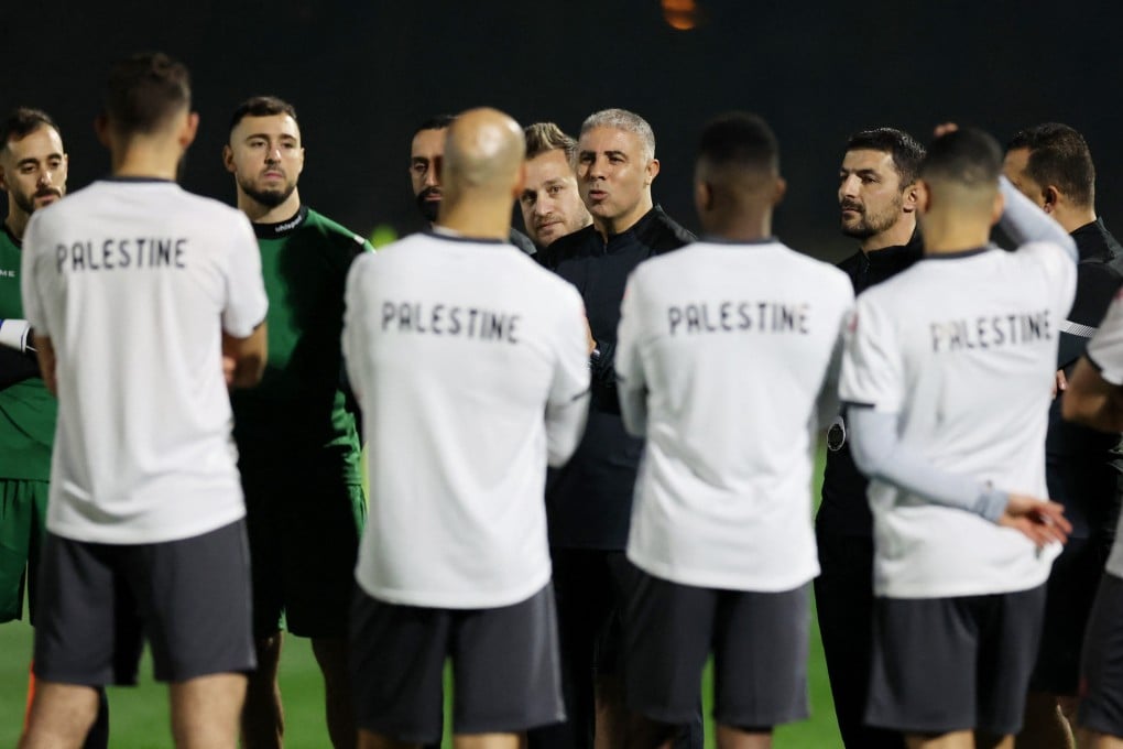 Palestine coach Makram Daboub speaks to his players during a training session in Doha. Photo: Reuters