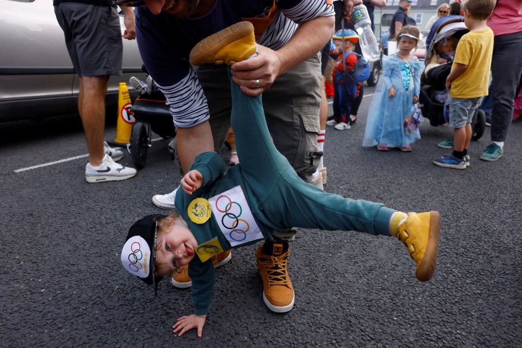 Brodie White, 1, dressed as Raygun, is held by his father at a children’s fancy dress parade in Kinvara, Ireland. Photo: Reuters