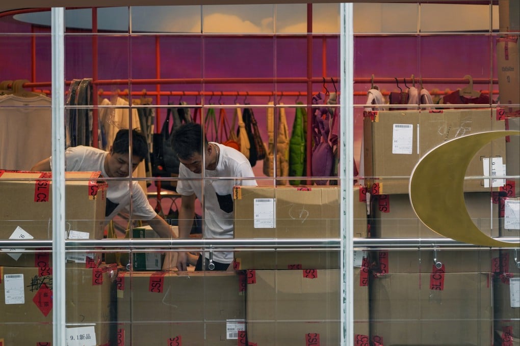 Workers load new arrival clothing stocks at a fashion boutique at an outdoor shopping mall in Beijing. Photo: AP