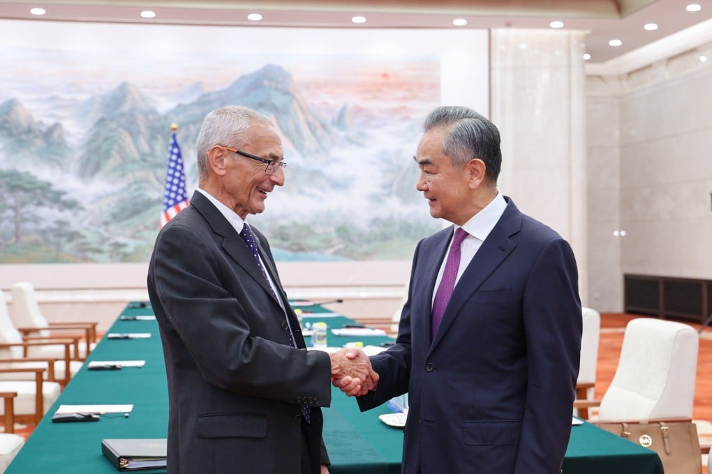 Chinese Foreign Minister Wang Yi greets US climate envoy John Podesta, in Beijing on Friday. Photo: Xinhua