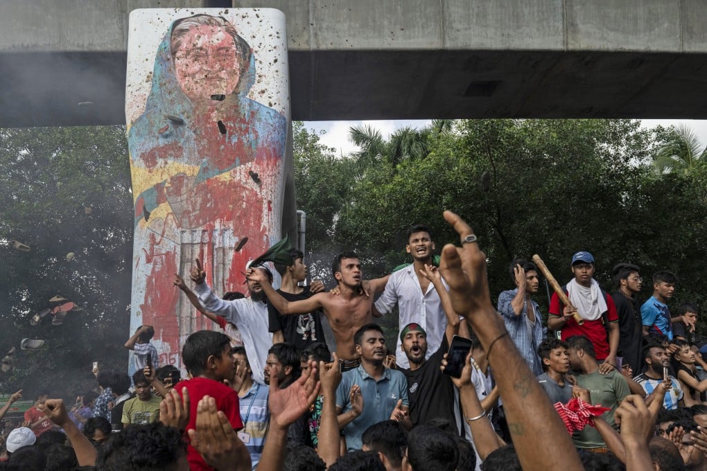 Protesters in Dhaka celebrate beside a defaced portrait of Bangladesh Prime Minister Sheikh Hasina after news of her resignation earlier this month. Photo: AP