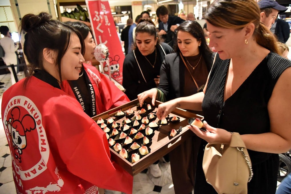 A customer tries peaches from Japan’s Fukushima prefecture, which went on sale at luxury department store Harrods in central London on September 7. Photo: AFP