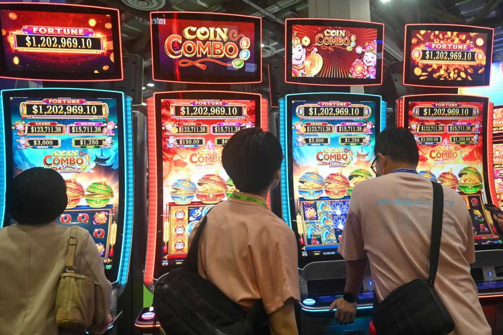 Visitors try out slot machines at an expo in Singapore. The revision is the latest change to casino rules in the city state. Photo: AFP