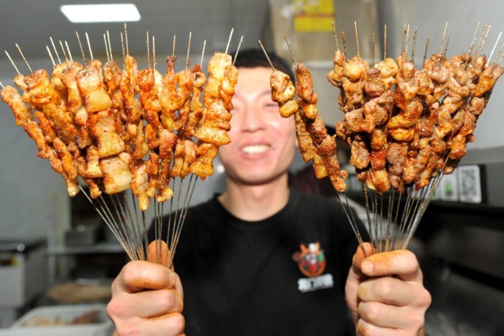 A chef shows off grilled meat at a barbecue eatery in Zibo, Shandong province. Photo: Xinhua