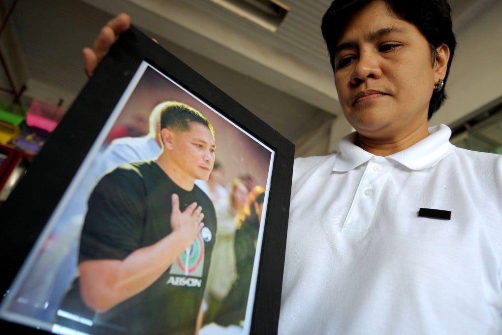 Patricia Ortega, wife of slain Philippine environment activist Gerry Ortega, shows the picture of her husband at a pet shop in Palawan’s capital city in 2011. Photo: AFP