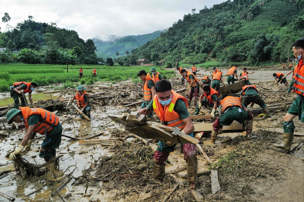 Rescue officials sift through debris at the site of a landslide in the remote mountainous village of Lang Nu, in Lao Cai province. Photo: AFP