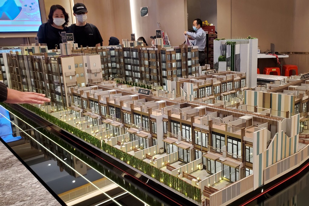 Potential buyers view a model of an apartment complex at the sales office of CK Asset’s LYOS housing development, in November 2021. Photo: Edmond So