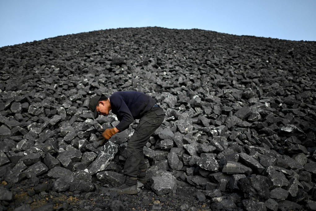 A worker sorts coal near a coal mine in Datong, in northern Shanxi province, in November 2021. China has made significant progress in lowering its carbon emissions, but that progress continues to be offset by the growth of the country’s coal sector. Photo: AFP