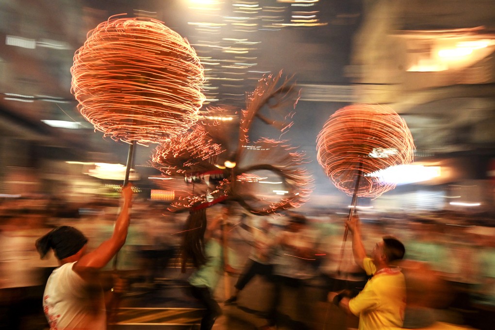 Members of the Tai Hang Fire Dragon Dance team spin balls of joss sticks as the “dragon” winds through Tai Hang, Hong Kong, during Mid-Autumn Festival celebrations on September 29, 2023. Such events are vital in preserving the city’s intangible cultural heritage, including its language traditions. Photo: AFP