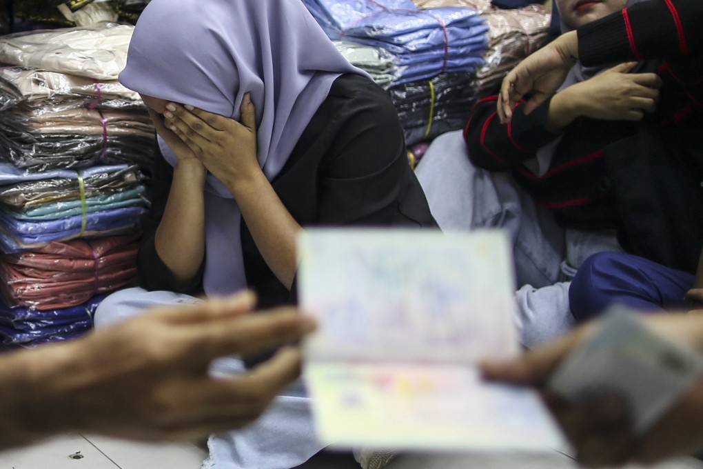 Detainees react during an immigration raid at a clothing store Malaysia on August 15. Photo: EPA-EFE