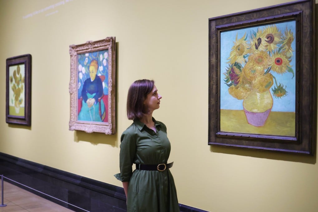 Two of Vincent van Gogh’s “Sunflowers” paintings flank The Lullaby at the National Gallery in London. The triptych is part of a major new exhibition of the Dutch painter’s works. Photo: EPA-EFE