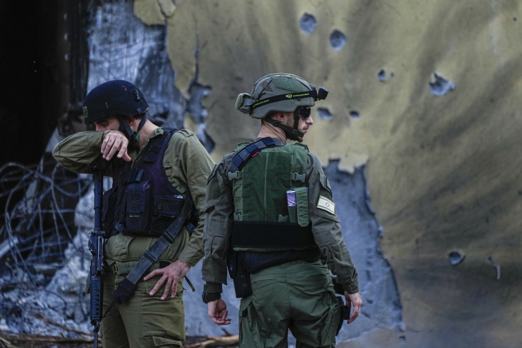 Israeli soldiers walk past houses destroyed by Hamas militants in Kibbutz Be’eri, Israel in October 2023. Photo: AP
