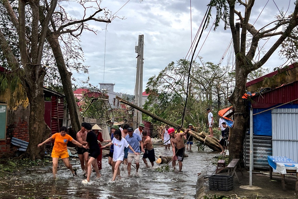 People in Haiphong use ropes to remove fallen trees after Typhoon Yagi swept through Vietnam earlier this month. Photo: Reuters