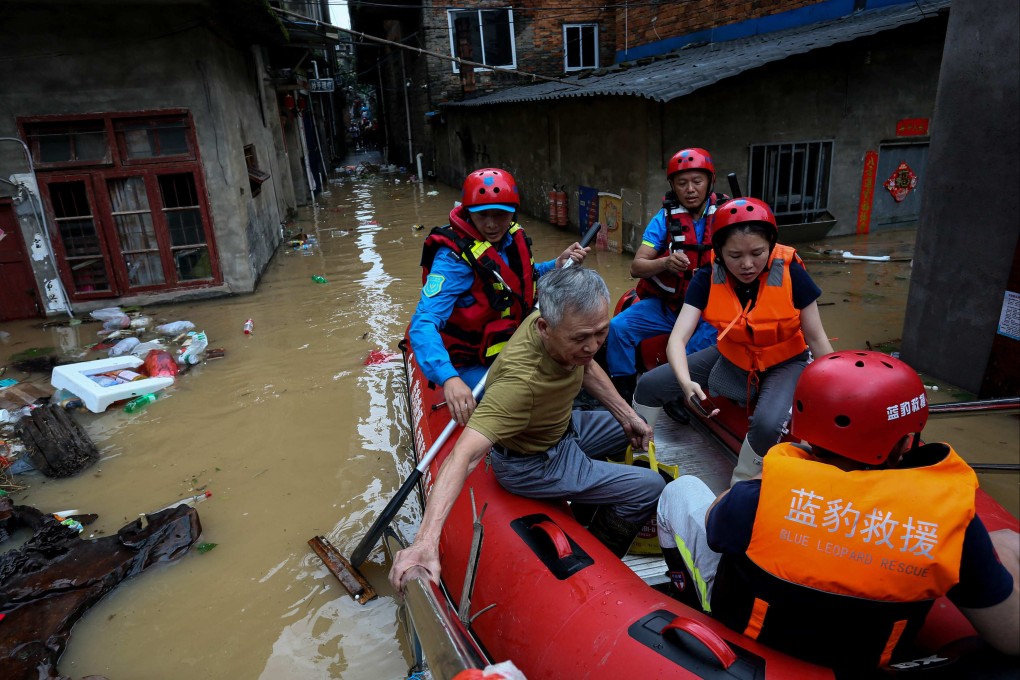 A villager sits on an inflatable boat with rescuers in a flooded part of Nanping, Fujian province, on June 16, after storms caused sever flooding. Photo: CNS/AFP