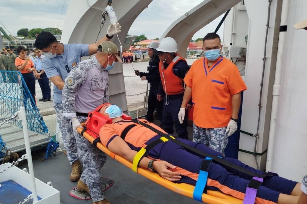 A sick crew member is removed from the BRP Teresa Magbanua on a stretcher after it arrived at port on Sunday. Photo: EPA-EFE
