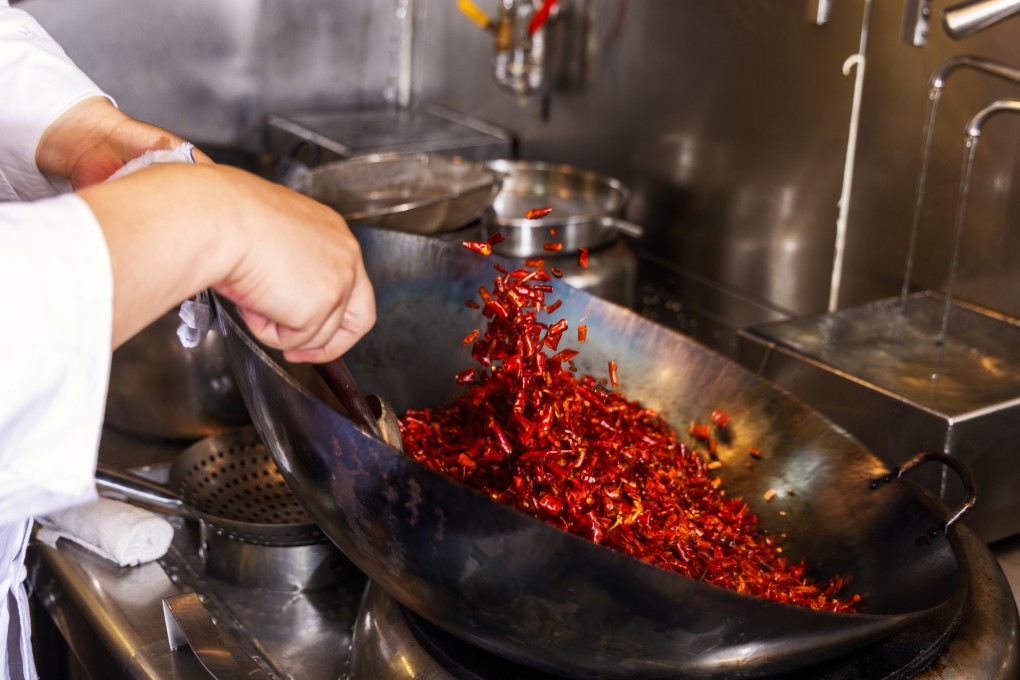 Ronald Shao, executive chef at Mian, at The Murray hotel in Hong Kong, cooks chilies to make the restaurant’s home-made chilli oil. Photo: Jocelyn Tam