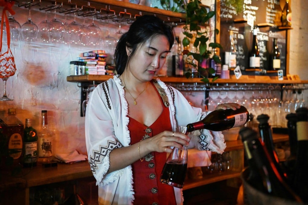 Sophie Zhou, owner of Uh-huh Wine Bar & Eatery in Beijing, China, pours wine at her bar on August 24, 2024. The Chinese wine industry is being propelled forwards by women, with many of its best wines coming from female-led producers, while the spirit of discovery shown by women influencers, bar owners and consumers is also playing a major part. Photo: AFP