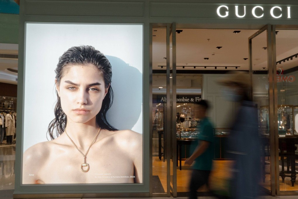 People walk past a Gucci store in the Wangfujing shopping area in Beijing on September 13. China’s slowing growth has begun to weigh on luxury brands. Photo: Bloomberg