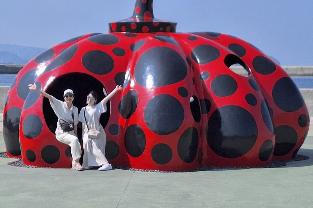 Two people pose for a photo seated on Red Pumpkin by Yayoi Kusama on Naoshima island, Takamatsu, Japan. The island is one of Japan’s foremost arts venues and should rank high on any list of what to do in Takamatsu. Photo: Ed Peters