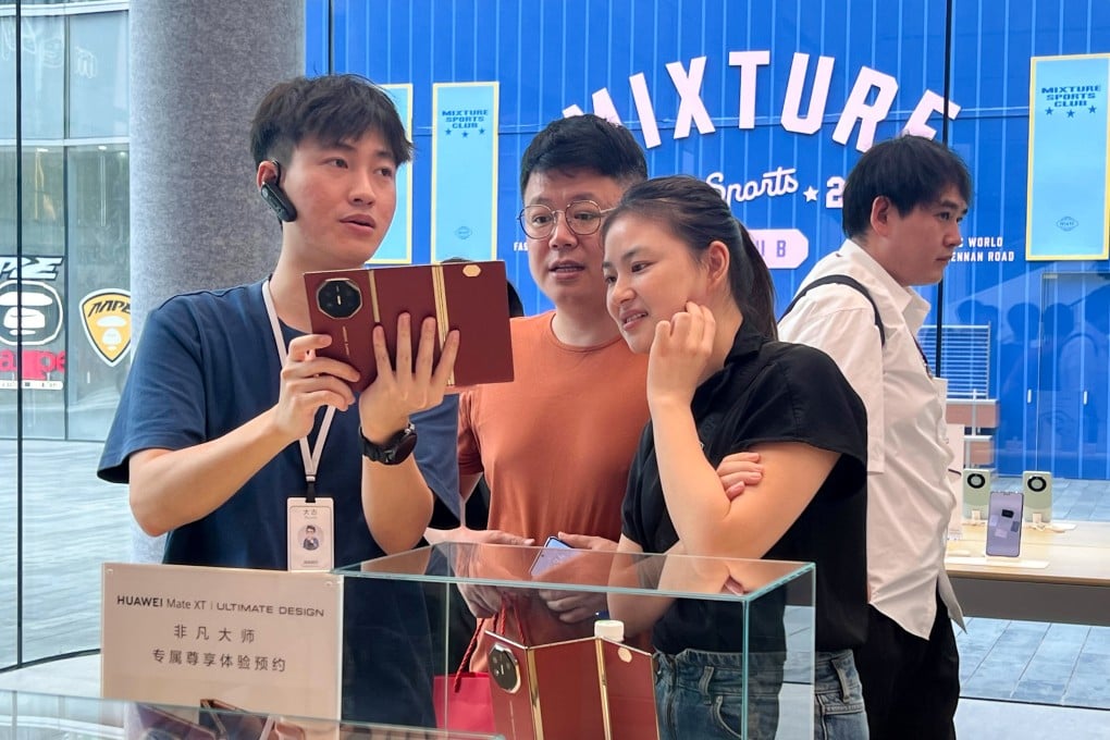 Huawei sales staff demonstrate the Mate XT tri-fold smartphone in its Shenzhen store on Friday. Photo: Iris Deng