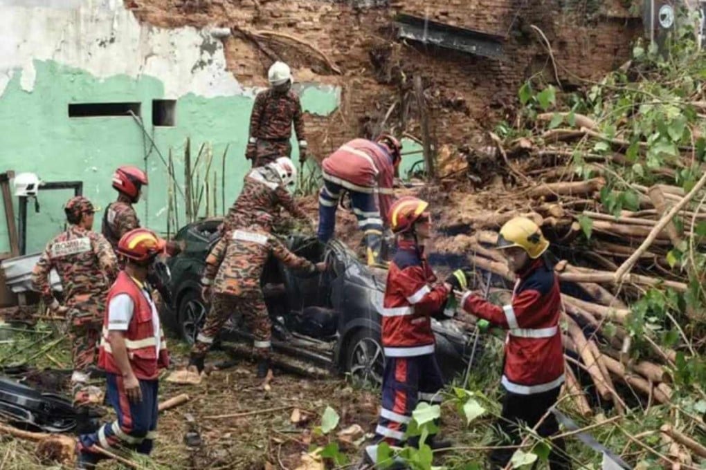 Rescuers remove the bodies of the victims from the car wreckage in Penang. Photo: Facebook/BombaMalaysiaOfficial